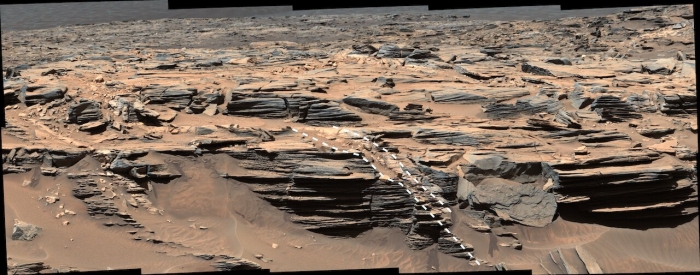 ゲールクレーターの岩盤層に沿って存在している光る堆積層（破線で取り囲まれた部分）。この実態は水を豊富に含むオパールである。(c) Malin Space Science Systems/NASA/JPL-Caltech