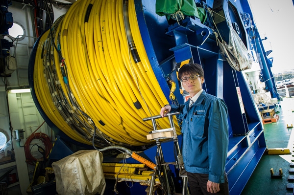 海洋研究開発機構の澤隆雄氏と深海調査研究船「かいれい」に搭載した深海ROV用ケーブル （写真提供：日産自動車）