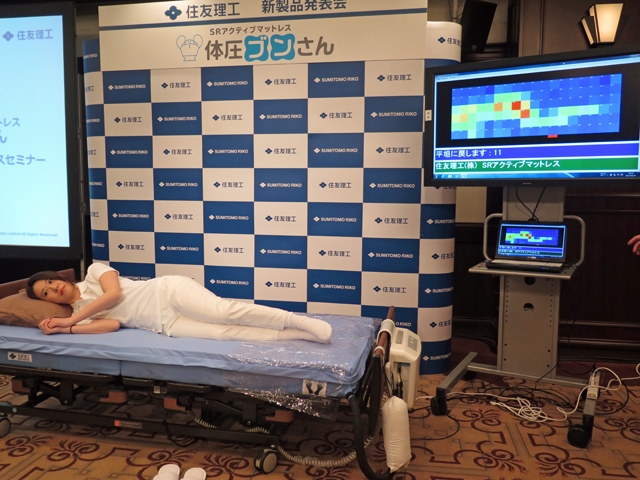発表会で行われたデモの様子。『SRアクティブマットレス 体圧ブンさん』に仰向けに臥床した状態から写真のように寝返りをうって横向きになると、センサーが察知して減圧を始める。写真右のモニターで赤くなっている部分の体圧がとくに高いことを示している