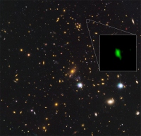 ハッブル宇宙望遠鏡が赤外線で撮影した銀河団MACS J1149.5+2223の画像の一角に、アルマ望遠鏡が電波で観測した銀河MACS1149-JD1を合成した画像。緑色が酸素の分布。（画像:国立天文台発表資料より）