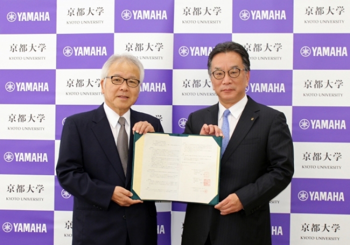 協定締結を発表した京都大学の阿曽沼慎司理事（左）とヤマハの川瀬忍常務執行役（写真：ヤマハの発表資料より）