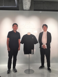 ブリュード・プロテインを使ったTシャツと、渡辺ゴールドウイン副社長（右）と関山スパイバー代表