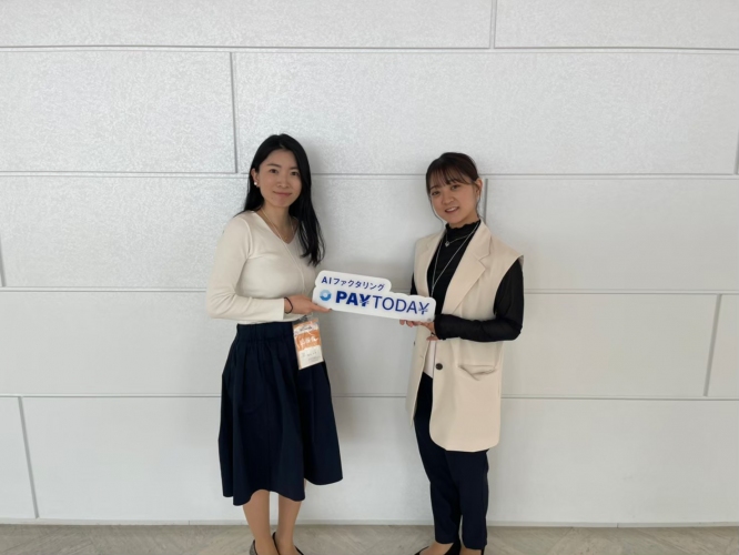 ロゴを持った取締役の田中氏（右）とスタッフ