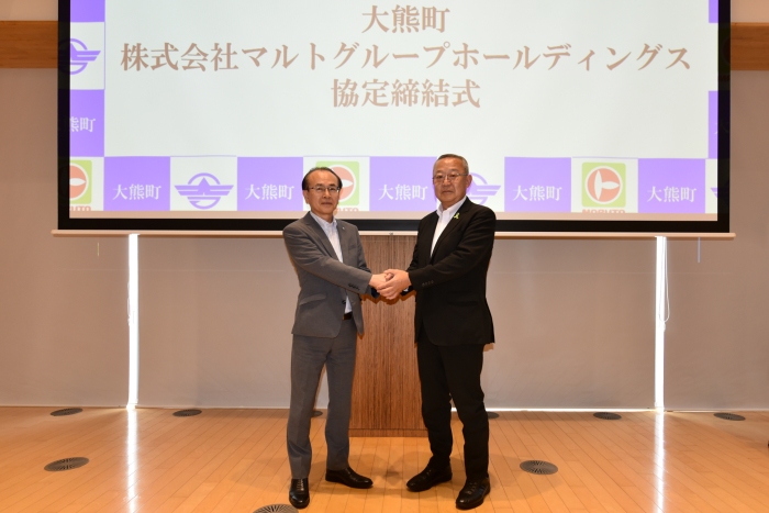 基本協定を締結し、握手を交わす吉田淳大熊町長㊧と安島宏マルトグループHD社長（大熊町発表資料より）
