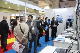 養殖の映像を前に来場者に案内する山本准教授(中央) 養殖の映像を前に来場者に案内する山本准教授(中央)