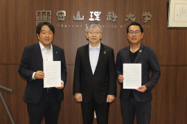 パートナーシップ契約を結んだ「(株)ウッディワールドのざき」の野﨑社長(左)と理大サッカー部の秦監督(右)。中央は平野学長 パートナーシップ契約を結んだ「(株)ウッディワールドのざき」の野﨑社長(左)と理大サッカー部の秦監督(右)。中央は平野学長