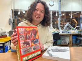 発刊された大図鑑を手にする林准教授＝理大恐竜学博物館で