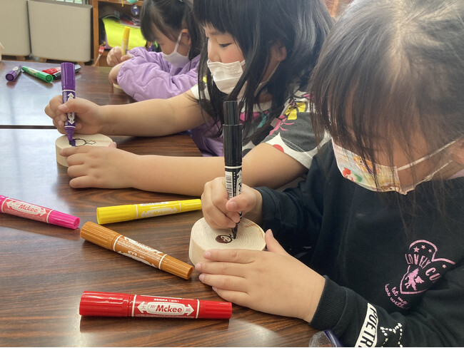 玉川温泉の母の日イベントに向けて、ときがわ町学童保育の子供たちが地元産ヒノキの入浴木にメッセージを書きます