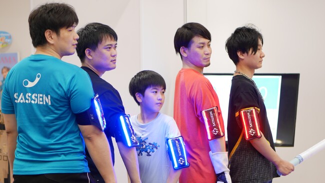 安全で大人数で楽しめるレクリエーションシステムの提供を開始！センサー内蔵の刀で戦うデジタルチャンバラSASSENが、集団戦向けウェアラブルデバイスを発表！