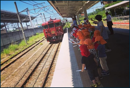 みつどんと駅長と一緒に手旗を振って「ろくもん」をお出迎え！
