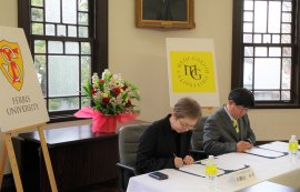 協定書に署名する小檜山学長(左)と今尾学長(右)