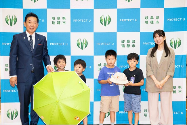 猛暑から子どもたちを守る新たな熱中症対策を実施　　　　　　　　瑞穂市、市内7校の新小学1年生約500名へ遮熱日傘・帽子「PROTECT U」を贈呈