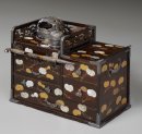 (Photo_03) 葵散し螺鈿蒔絵たばこ盆 16.9×31.5×25.6cm 売立目録には「一七一 紫檀葵蒔繪莨盆 銀牡丹彫煙管付」として載っている。昭和初期に大蔵省専売局により収集され、現在は当館の収蔵品となっている。 (Photo_03) 葵散し螺鈿蒔絵たばこ盆 16.9×31.5×25.6cm 売立目録には「一七一 紫檀葵蒔繪莨盆 銀牡丹彫煙管付」として載っている。昭和初期に大蔵省専売局により収集され、現在は当館の収蔵品となっている。
