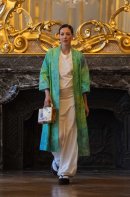 伊砂正幸氏の染色作品によるグリーンの羽織。ゴールドのボックス型バッグを手に